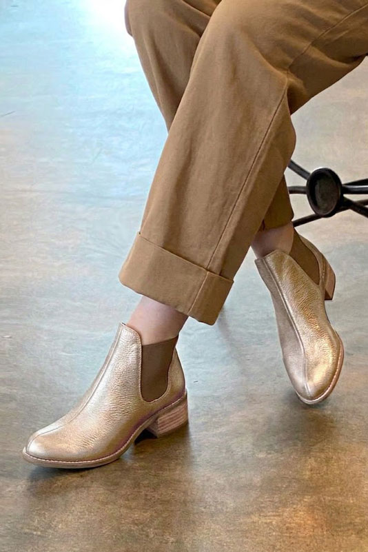 Women's gold and bronze solid-color chelsea boots with round toe and leather sole - Worn view